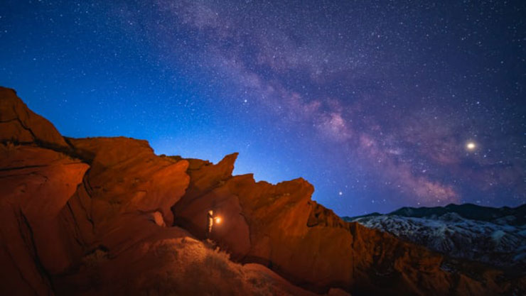 Ibraim Almazbekov poses with a lantern in the Fairytale Canyon as the Milky Way appears in the sky.