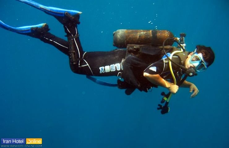 گردشگری که با تجهیزات حرفه‌ای مشغول غواصی در کلبه غواصی چابهار است