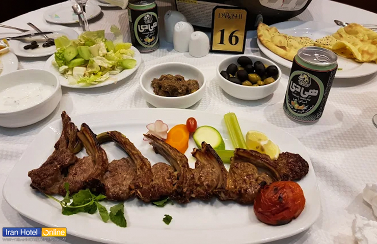 قیمت غذاهای هتل درویشی مشهد، تجربهای متفاوت از طعمهای لذیذ! 3 عکسی از میز غذای ایرانی با کباب لذیذ در کنار سالاد و زیتون و... با دیزانی زیبا از منوی ایرانی هتل درویشی مشهد