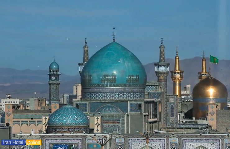 تصویری زیبا از گنبد فیروزه ای و منارهای مسجد گوهرشاد در کنار ضریح امام رضا