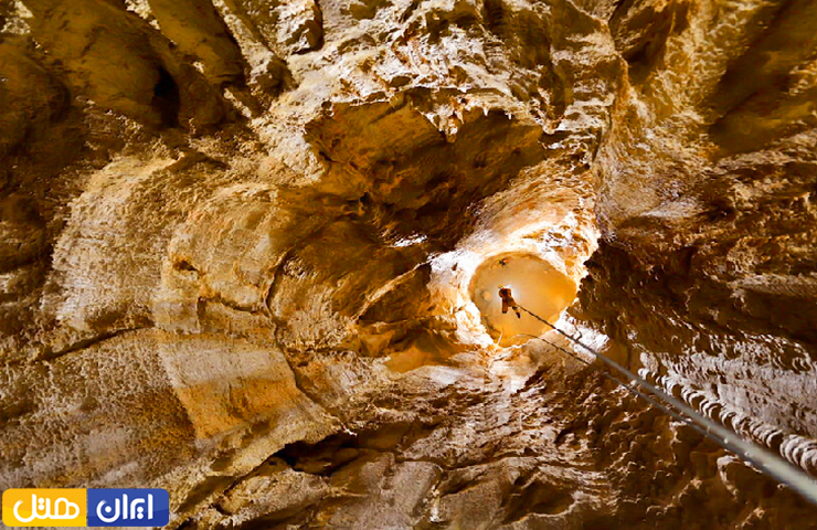 جاهای دیدنی کرمانشاه؛ از معبد آناهیتا تا بیستون زیبا! 14 تصویری از یک غار نورد که با تجهیزات حرفهای در میان غار پرآو دیده میشود